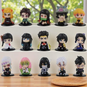 May include: A white ceramic mug with a black handle and the text "But First, Coffee" in a black, handwritten-style font. The mug is on a white surface.