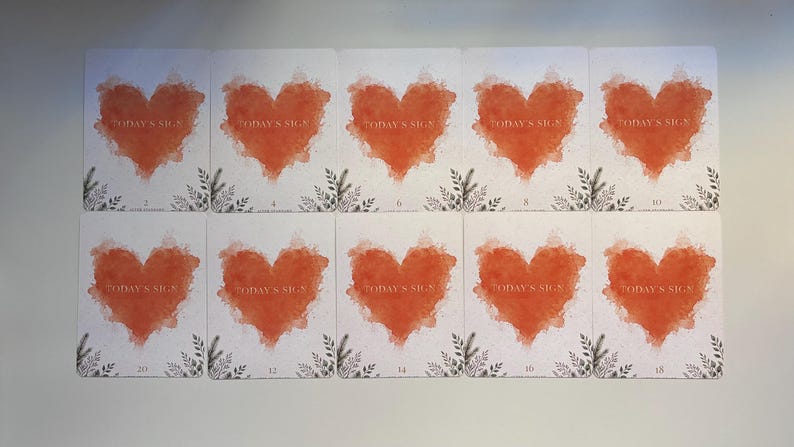 May include: Ten rectangular cards arranged in two rows of five. Each white card features a central orange watercolour heart with the text "TODAY'S SIGN" printed in white. The bottom of each card displays a small black botanical illustration.