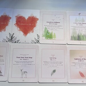 May include: A collection of ten rectangular oracle cards arranged in two rows. The cards feature various illustrations including red watercolour hearts, green pine trees, a deer, a feather, and horses, alongside English and Japanese text titles.
