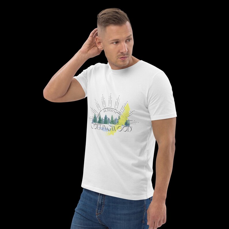 Pode incluir: Uma t-shirt branca de manga curta com uma impress&atilde;o gr&aacute;fica de uma paisagem florestal, o texto COLLINGWOOD e 44.5000&deg;N. O design inclui raios de sol estilizados sobre as &aacute;rvores e um detalhe amarelo de pincelada no centro do gr&aacute;fico.