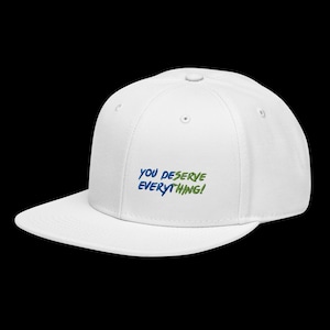 May include: A white baseball cap with a flat brim and a structured crown. The front of the cap features embroidered text in blue and green that reads, "YOU DESERVE EVERYTHING!" The cap includes a top button and ventilation eyelets on the panels.