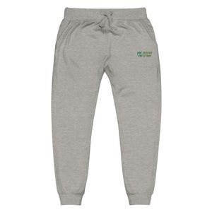 May include: Light grey sweatpants featuring an elastic waistband with a drawstring and ribbed cuffs at the ankles. The front right side displays the embroidered green text "YOU DESERVE EVERYTHING" in a stylised, slightly slanted font.