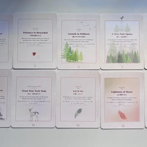 May include: Ten rectangular cards arranged in two rows, each featuring a unique title, descriptive text in English and Japanese, and a small illustration. The cards depict themes like nature, animals, and abstract concepts with soft, muted colour gradients.
