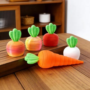 May include: A collection of carrot-shaped items, including several small, round carrot-topped objects in shades of orange, red, and white, and a larger, elongated carrot. The carrots have green tops and are arranged on a wooden surface.