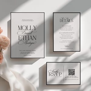 May include: Elegant wedding invitation suite featuring a main invitation, details card, and RSVP card. The cards have a minimalist design with black text on a light background, framed by a black border. Soft pink roses and white fabric add a touch of romance.