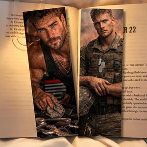 May include: Two bookmarks featuring images of men. One man is in a garage setting, wearing a black tank top and working on a car. The other man is in military attire, with dog tags, and a serious expression. The bookmarks are placed in an open book.
