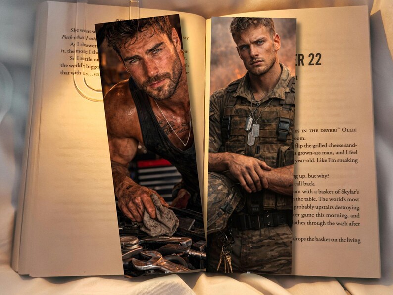 May include: Two bookmarks featuring images of men. One man is in a garage setting, wearing a black tank top and working on a car. The other man is in military attire, with dog tags, and a serious expression. The bookmarks are placed in an open book.