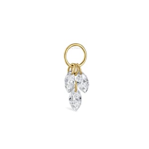 Könnte beinhalten: Ein goldfarbener Ohrring-Anhänger mit drei klaren, marquiseförmigen Edelsteinen, die an einem kleinen Ring hängen. Die Edelsteine sind in einer Gruppe angeordnet und bilden ein zartes und elegantes Design. Der Anhänger ist vor einem schlichten weißen Hintergrund platziert.