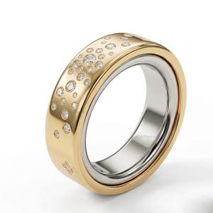 May include: A two-tone ring with a gold band and a silver inner ring. The gold band is adorned with numerous small, sparkling diamonds. The ring has a modern design and is set against a white background.