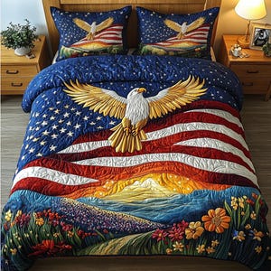 Könnte beinhalten: Eine gesteppte Bettdecke und zwei Kissenbezüge mit einem amerikanischen Flaggenmuster und einem goldenen Adler. Die Bettdecke hat einen blauen Hintergrund mit weißen Sternen, roten und weißen Streifen und eine Landschaftsszene mit Blumen.