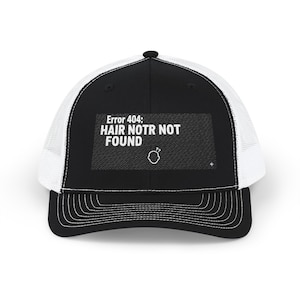 May include: Black and white trucker hat with the text "Error 404: HAIR NOTR NOT FOUND" in white. The hat features a black front panel, a white mesh back, and a curved brim. A small graphic of a head is also present.