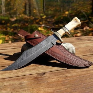 May include: A white ceramic mug with a black handle and the text "But First, Coffee" in a black, bold font. The mug is on a white surface. The mug is approximately 4 inches tall.