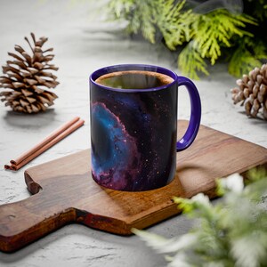 May include: A set of three ceramic mugs with a speckled, cream-colored glaze. Each mug features a different hand-painted floral design in shades of blue, green, and yellow. The mugs have a simple, rounded shape and a comfortable handle.