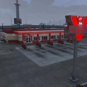 May include: Exterior shot of a gas station with a red and white color scheme. The sign reads "THE VARS" in red letters. The building has multiple gas pumps and a red roof. The sky is overcast.
