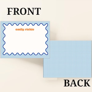 May include: A set of personalized stationery cards. The front of the card features a white rectangular space with a blue wavy border and the name "emily richie" in orange. The back of the card has a blue and white gingham pattern. The word "FRONT" and "BACK" are displayed.