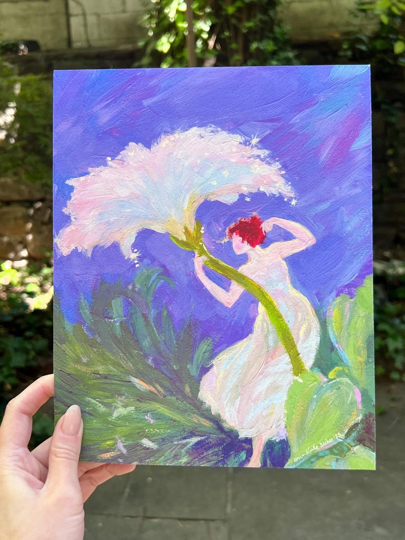 Puede incluir: Pintura original que representa una figura con un vestido blanco que alcanza una gran flor blanca. La obra de arte tiene una paleta de colores vibrantes de azules, verdes y rosas. La pintura est&aacute; sostenida por una mano.