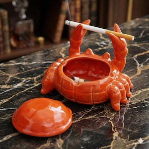 以下が含まれることがあります： 黒いハンドルと「But First, Coffee」のテキストが黒い太字で書かれた白いセラミックマグ。 マグカップは木製の表面に置かれています。