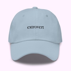 Op de afbeelding: Lichtblauwe baseballcap met het woord "extrovert" in zwarte letters. De cap heeft een gebogen klep en een verstelbare band. Een casual en comfortabel accessoire.