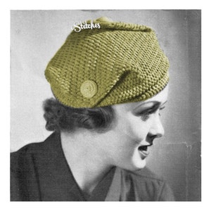 May include: A vintage black and white photograph of a woman wearing a green crocheted hat with a button on the side. The hat is styled in a slouchy, casual way. The photo is from the 1940s.