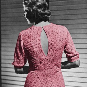 Puede incluir: Un suéter de punto rosa con un gran diseño de espalda abierta. El suéter tiene un cuerpo ajustado y mangas cortas.