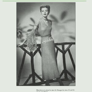 May include: A black and white photo of a woman wearing a crocheted dress and matching shawl. The dress has a V-neckline and short sleeves. The woman is standing in front of a wooden fence.