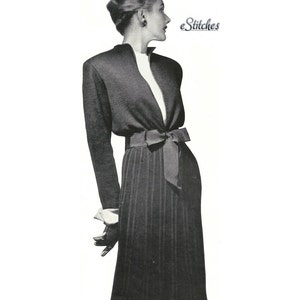 May include: A black and white photo of a woman wearing a long, fitted, black dress with a wide, black sash tied in a bow at the waist. The dress has a V-neckline and long sleeves. The woman has her hair styled in a bun and is looking to the right. The text "eStitches" is visible in the upper right corner of the image.