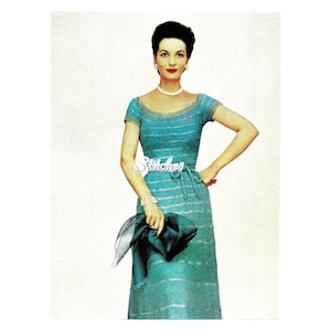 May include: A teal blue knitted dress with a white stripe pattern. The dress has a scoop neckline, short sleeves, and a fitted bodice. The model is wearing a pearl necklace and a black clutch.