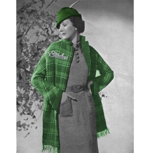 May include: A woman wearing a green plaid jacket with a green hat and a feather. The jacket has a patch that says "eStitches".