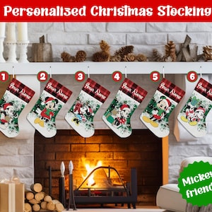 May include: Six Christmas stockings featuring Disney characters Mickey and Minnie Mouse in holiday attire. Each stocking has a red and black buffalo plaid cuff with the text Your Name, and a white body with green pine branch graphics.