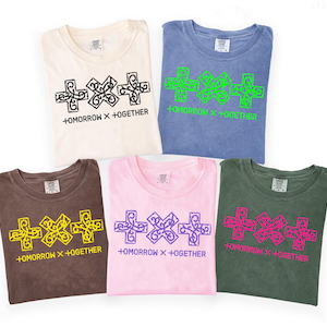Puede incluir: Cinco camisetas dobladas en crema, azul, marrón, rosa y verde. Cada camiseta presenta un gráfico de tres cruces y el texto "+OMORROW X +TOGETHER" en negro, verde, amarillo, morado y rosa.