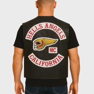 Puede incluir: Chaleco de cuero negro con el parche "Hells Angels California". El parche presenta un emblema de calavera alada en rojo y amarillo, con las letras "MC" en un pequeño cuadro blanco.