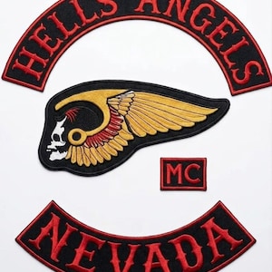 May include: Set of embroidered patches featuring the words "HELLS ANGELS" in a red arched design, a skull with a winged design, the word "NEVADA" in a red arched design, and a small "MC" patch. The patches are black with red and gold accents.