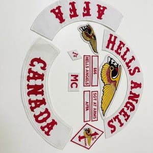 May include: A collection of patches featuring the words "HELLS ANGELS" and "CANADA" in red lettering on white backgrounds. Includes patches with the text "AFFA", "MC", "SGT AT ARMS", and a diamond-shaped patch with "HAMC".