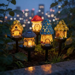 Op de afbeelding: Een verzameling verlichte tuinpalen in de vorm van grillige fee&euml;nhuizen. Elk huis heeft unieke details, waaronder bloemen- en paddenstoelaccenten en zonnepanelen. De huizen worden verlicht met een warme gloed, wat een magische sfeer cre&euml;ert.