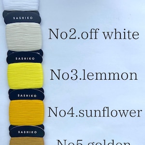 May include: Five spools of Sashiko thread wrapped on dark cards, labeled No.1 white, No.2 off white, No.3 lemmon, No.4 sunflower, and No.5 golden brown. Each spool contains 40m of 100% cotton thread, with the bottom spool showing 20/4 specifications.