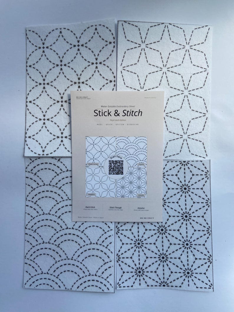 May include: Four white water-soluble embroidery sheets featuring black dashed geometric patterns, arranged around a central instruction card labelled Stick & Stitch with a QR code, text, and diagrams for peeling, stitching, and dissolving.