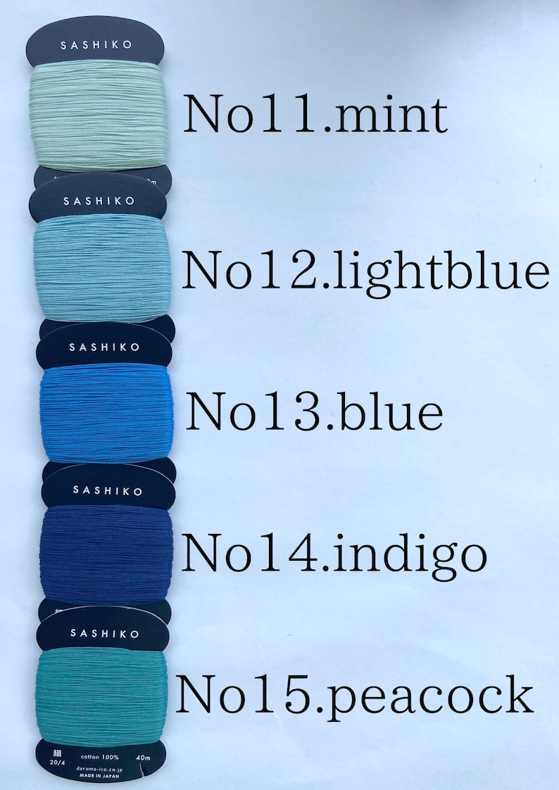 May include: Five spools of Sashiko thread wrapped on dark blue cardboard cards, labeled No11.mint, No12.lightblue, No13.blue, No14.indigo, and No15.peacock. Each spool contains 40m of 100% cotton thread, with the text Made in Japan visible.