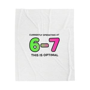 May include: White blanket with the text "CURRENTLY OPERATING AT 6-7 THIS IS OPTIMAL" in black, green, and pink. The numbers 6 and 7 are in green and pink, respectively, with a gradient bar between them. The blanket is folded.