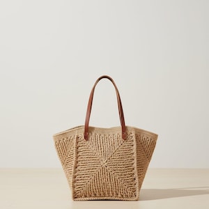 May include: A white ceramic mug with a black handle and the text "But First, Coffee" in a handwritten style. The mug is on a white surface. The mug is approximately 10 cm tall.