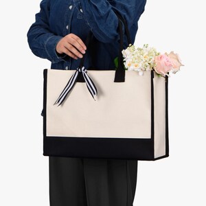 a woman holding a white and black bag
