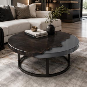 May include: A round coffee table featuring a split design with one half made of dark brown wood with a natural live edge and the other half made of smooth grey material. The table is supported by a black metal frame with a circular base.