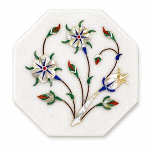 May include: White octagonal marble coaster with inlaid floral design. The flowers feature mother-of-pearl petals, red and blue accents, and green leaves. The coaster is a decorative item.