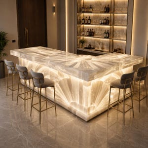 May include: An L-shaped bar counter made of translucent white stone with an integrated internal light source that illuminates the surface and base. Four gray upholstered bar stools with thin gold metal frames are positioned around the counter.