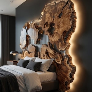 Peut inclure: Chambre avec une tête de lit unique, faite à partir d'une section de tronc d'arbre. La tête de lit est éclairée par un éclairage chaleureux. Le lit est fait avec du linge de maison blanc et des oreillers gris foncé. La pièce a une ambiance moderne et luxueuse.