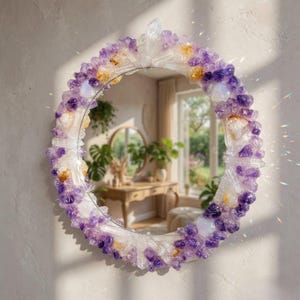 May include: Round mirror with a decorative frame made of amethyst, quartz, and citrine crystals. The crystals are arranged in a circular pattern around the mirror's edge, with a mix of purple, white, and yellow hues. The mirror is hanging on a light-colored wall.