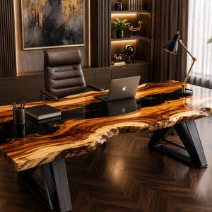 May include: A large executive desk featuring a natural live-edge wood slab surface with a central black resin inlay. The desk is supported by two black metal geometric legs and holds a silver laptop, a black notebook, and a black pen holder.