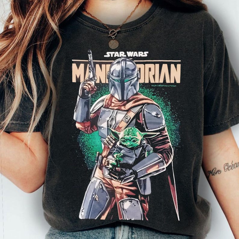 Pu&ograve; includere: T-shirt nera con una grafica di The Mandalorian che tiene Grogu di Star Wars. Il Mandaloriano &egrave; in armatura argentata, con un blaster. Grogu &egrave; verde e tenuto tra le braccia del Mandaloriano. Le parole "STAR WARS" e "MANDALORIAN" sono stampate sulla maglietta.
