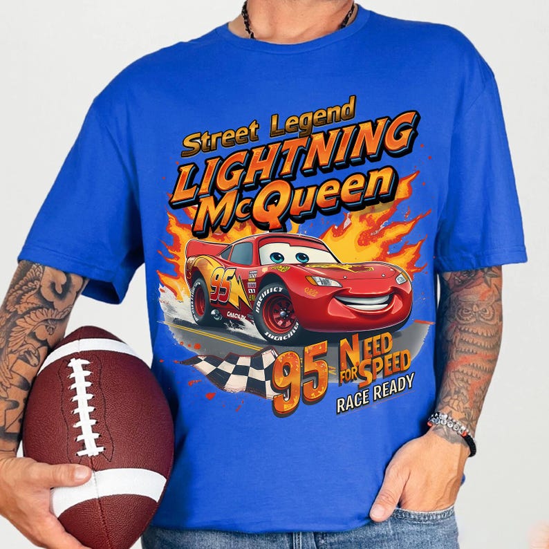 May include: Royal blue t-shirt featuring Lightning McQueen from the Cars movie. The design includes the text "Street Legend Lightning McQueen" and "95 Need for Speed Race Ready" with a graphic of the race car.