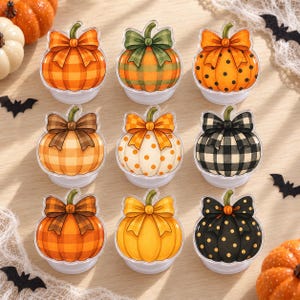 May include: A set of nine decorative pumpkin-shaped items arranged in a grid. Each pumpkin features a distinct pattern, including orange plaid, green plaid, orange polka dots, brown plaid, white with orange dots, black plaid, and black with gold dots.