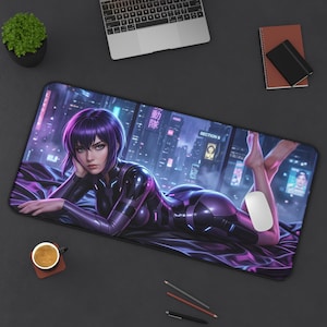 Puede incluir: Alfombrilla de ratón rectangular con una ilustración de estilo anime futurista de una mujer con un body morado, sobre un fondo de paisaje urbano. La alfombrilla tiene un borde negro y se ve un ratón blanco.